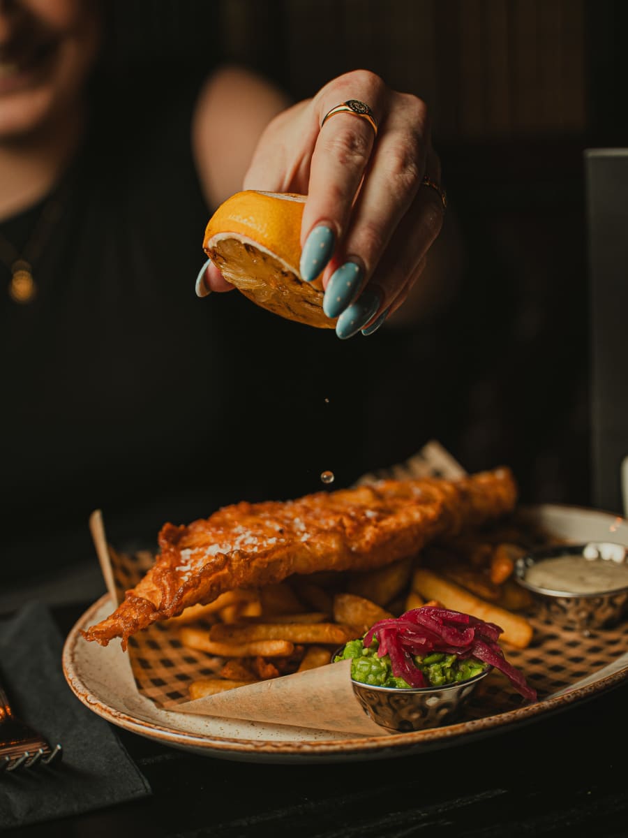 Charred lemon squeezed over beer-battered fish and chips at Merchant Tavern, Edinburgh