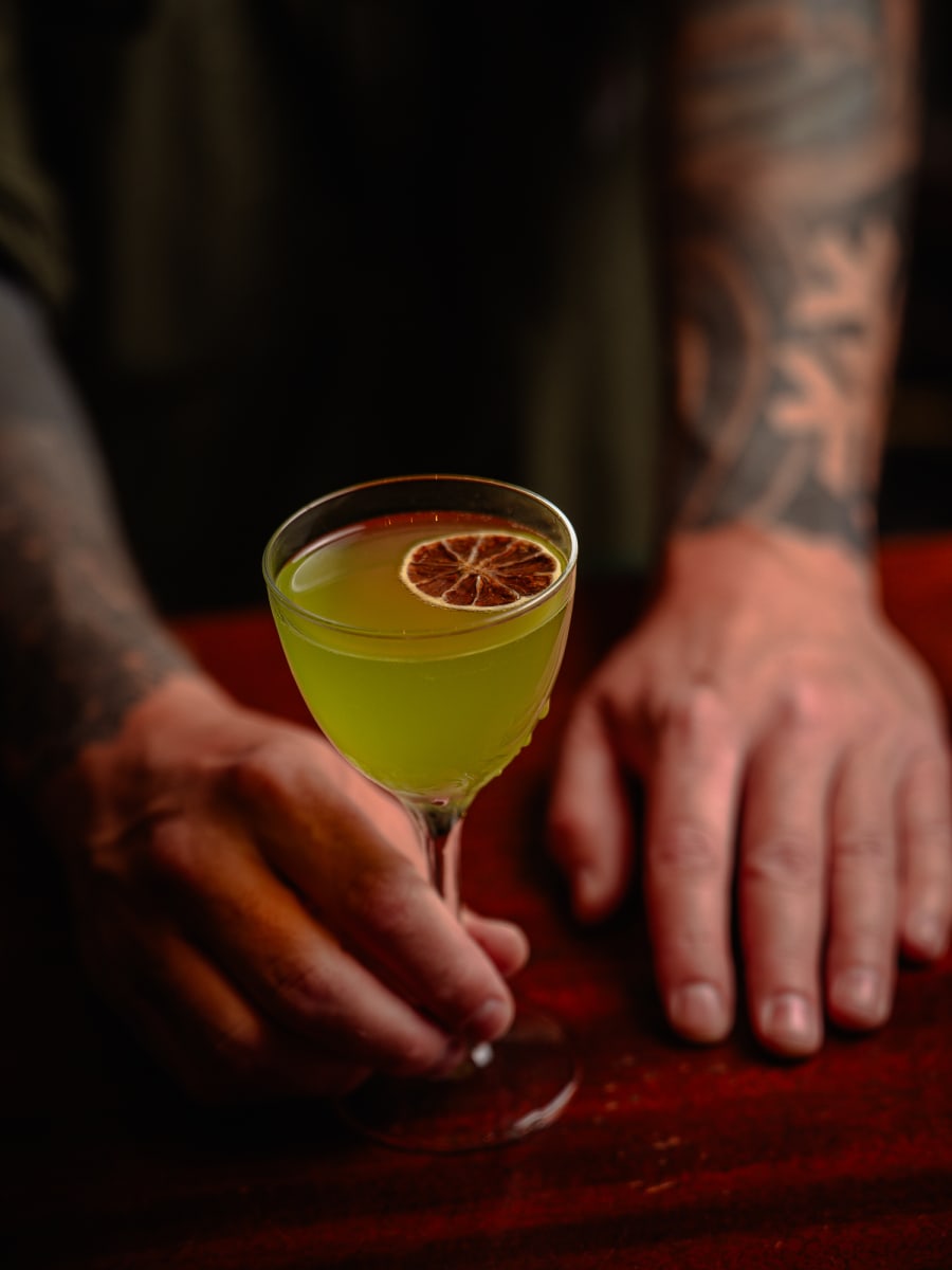Bartender presenting a green Diplomatico daiquiri at The Dome