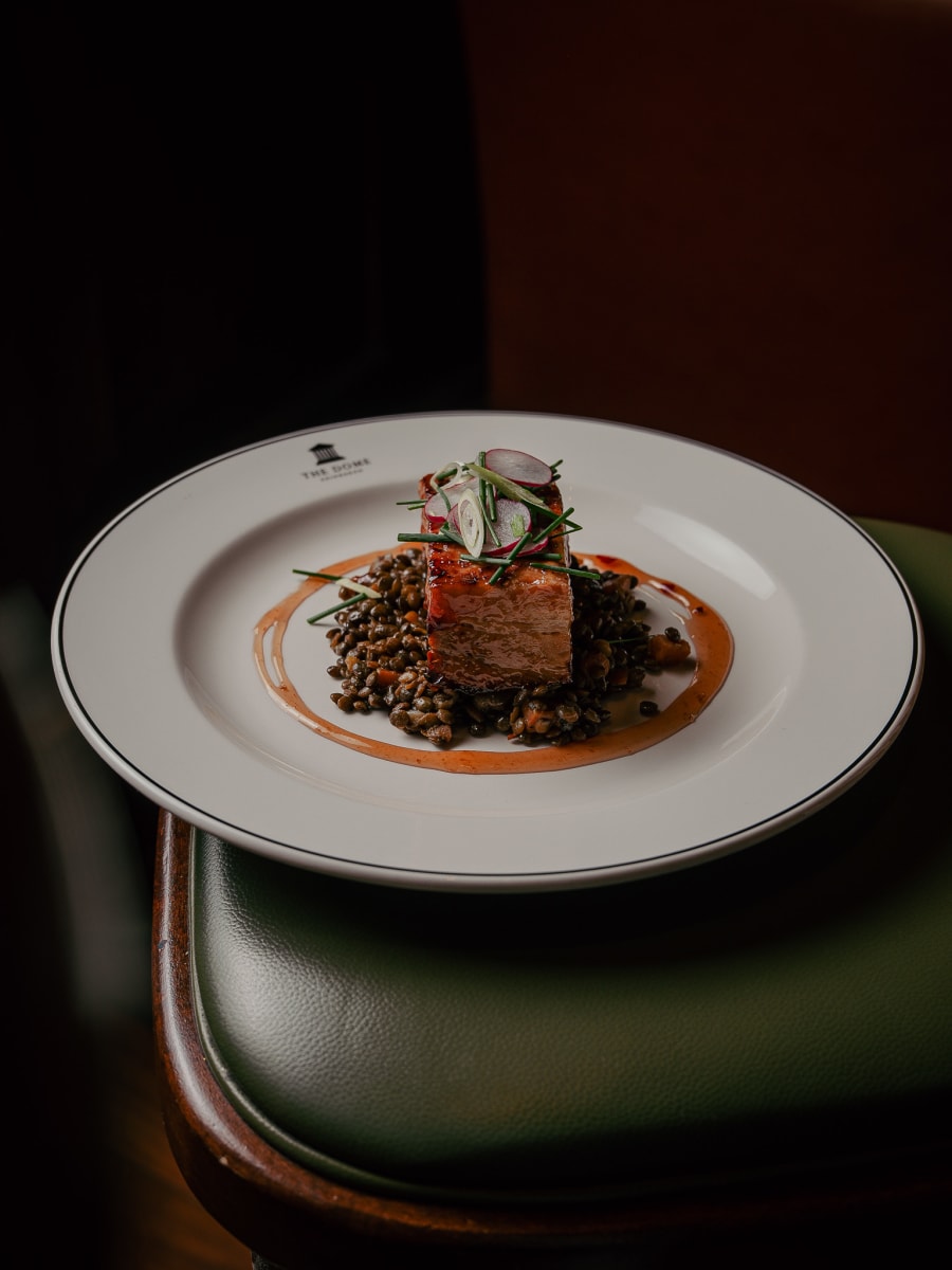 Pork with Puy lentils on the green leather chair at The Dome, Edinburgh