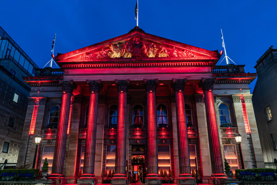 The Dome Edinburgh facade lit in red against the dusk sky