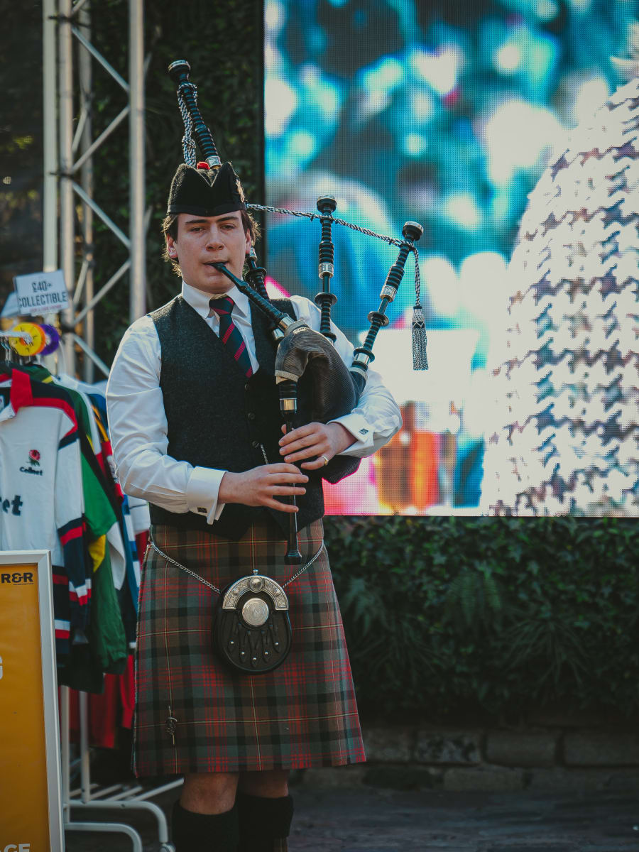 Kilted bagpiper playing in front of the big screen at The Pear Tree beer garden, Edinburgh