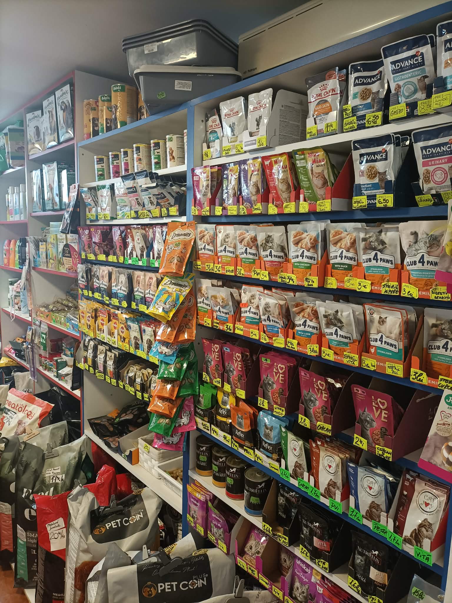 Pungi de hrană umedă pentru pisici si caini, aliniate pe raft într-un petshop din Brăila