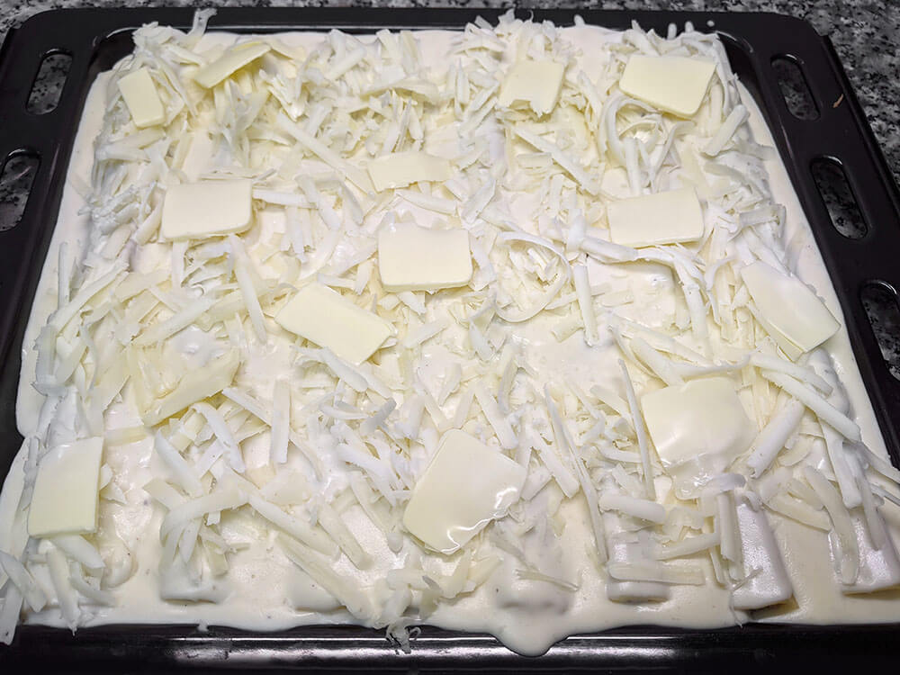 Canelones con queso rallado.