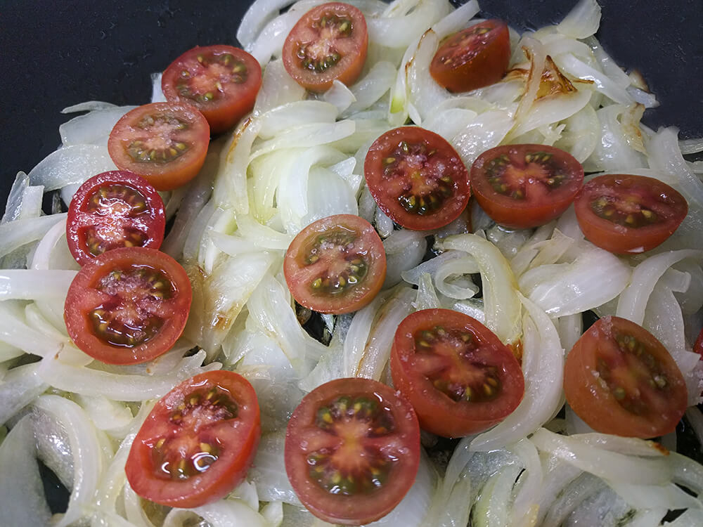 Cebolla en juliana con los tomates cherry rehogándose