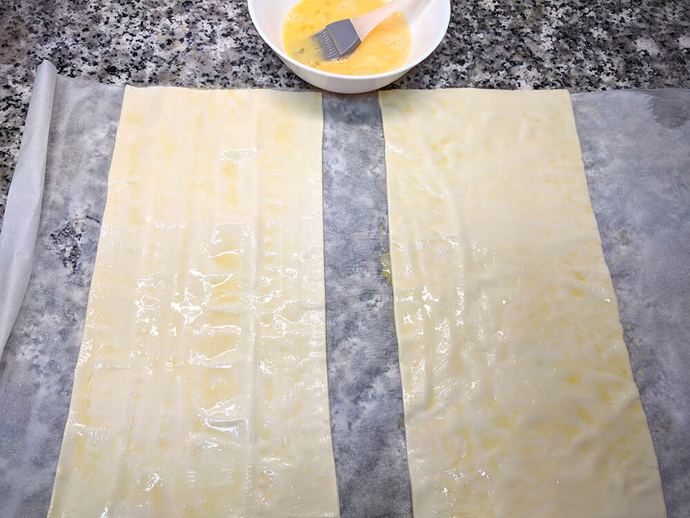 Masa de hojaldre fresca, cortada por la mitad.