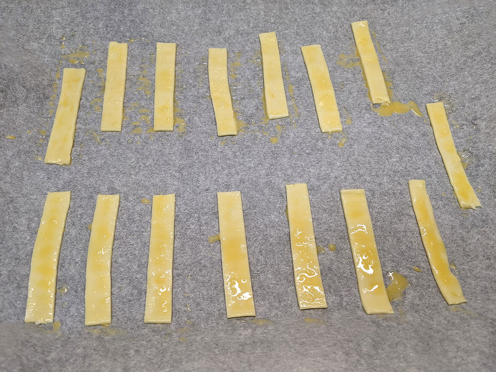 Bastones de hojaldre pintados con huevo batido.