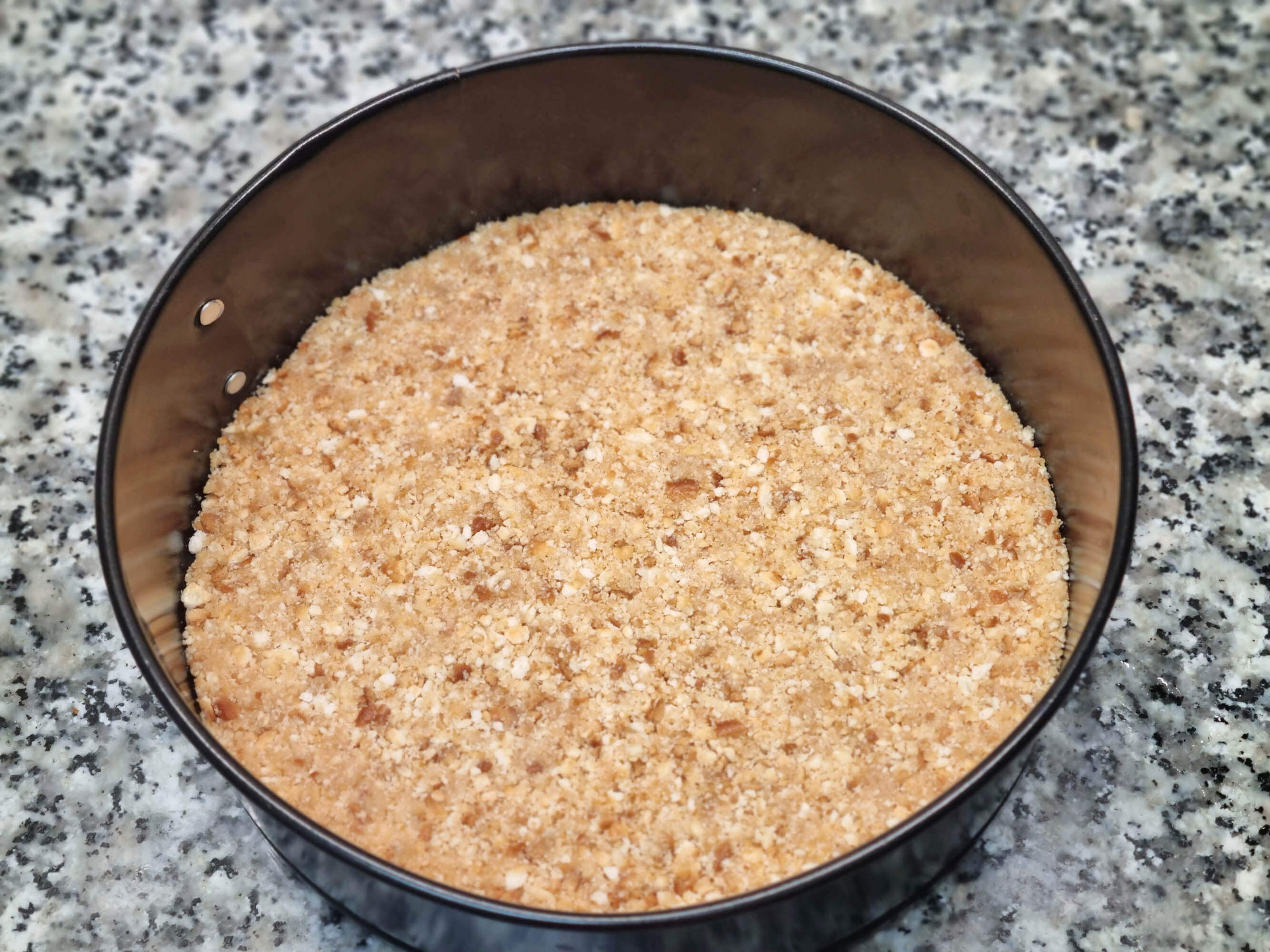 Base de galletas picadas y mantequilla.