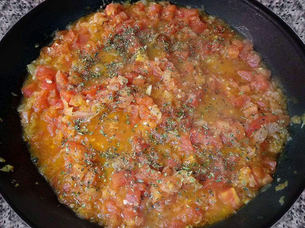 Cebolla picada, tomate a dados y orégano.