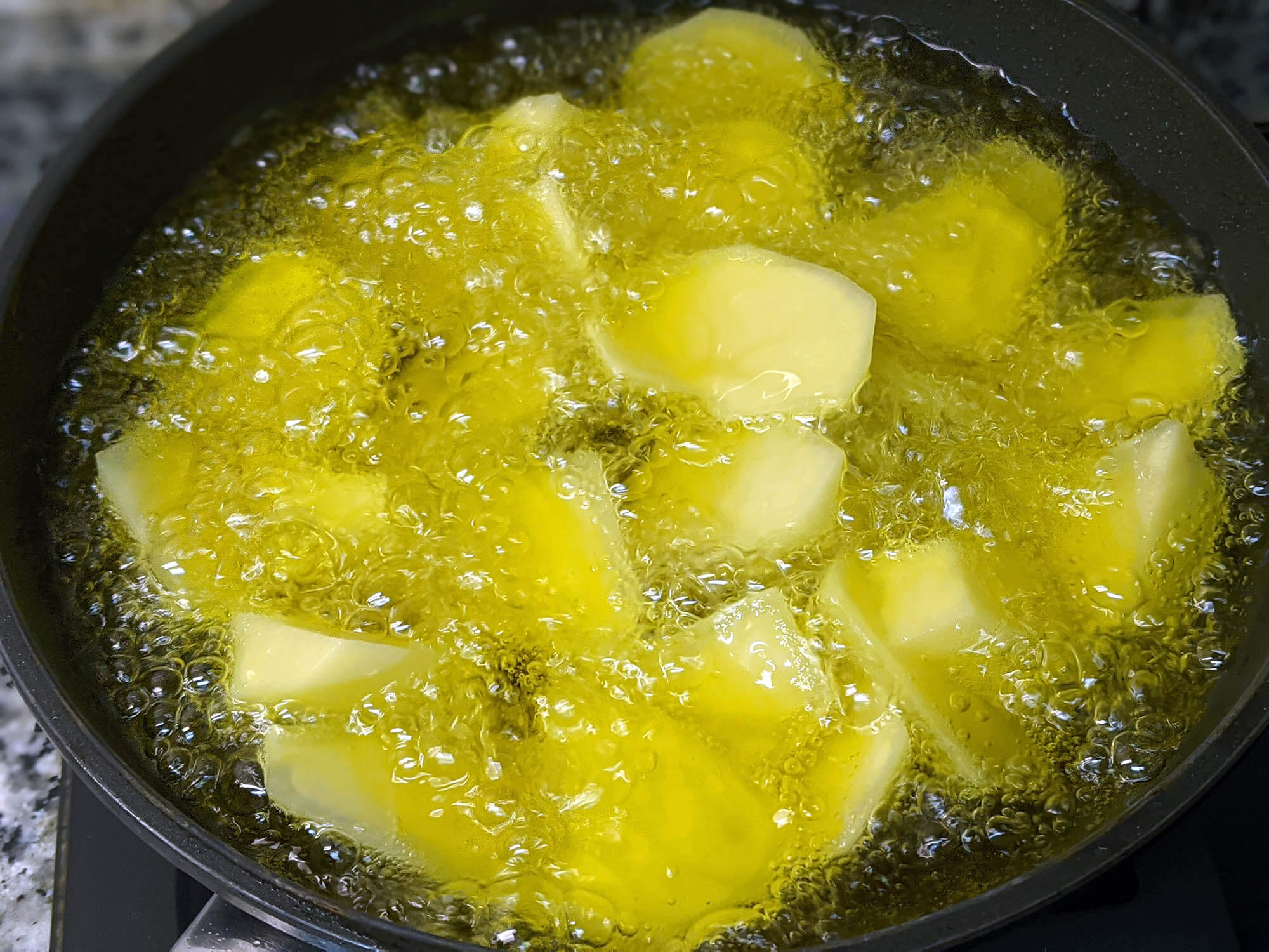 Patatas crudas en sartén.