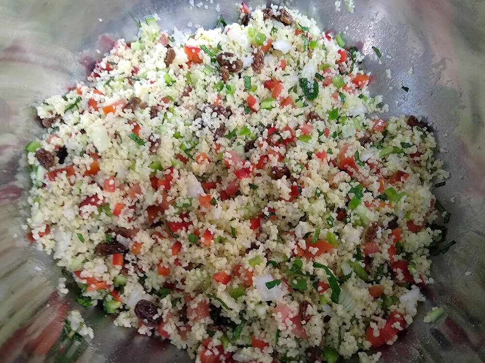 Cuscús, pepino, cebolleta, pimientos rojo y verde, tomate, menta y perejil mezclados.