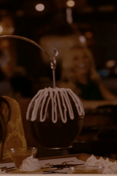 People sitting at a table with hanging pinata of chocolate