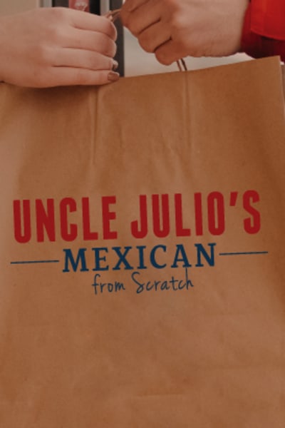 Uncle Julio's to go order being handed off to customer