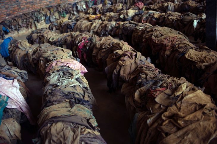 The clothes of victims killed during the Rwandan genocide are laid out on benches