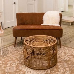 Sitting area with 2 white wicker chairs and a couch