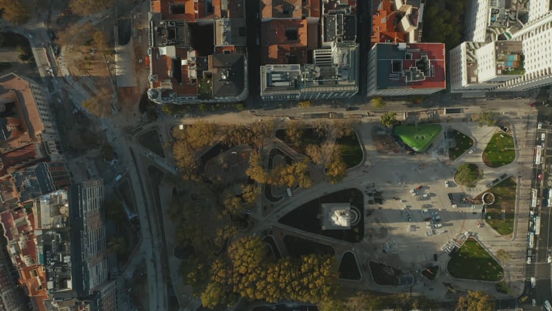 Aerial birds eye overhead top down panning footage of Plaza de Espana square and surrounding streets. Rooftop shot of apartment buildings in residential neighbourhood.