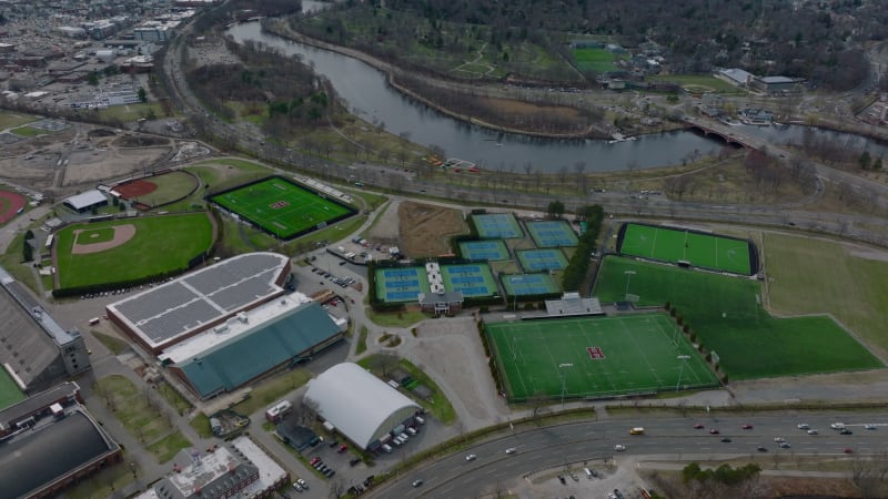 Sport area for various disciplines. Aerial view of university sports centre. Cars driving on busy multilane road. Boston, USA