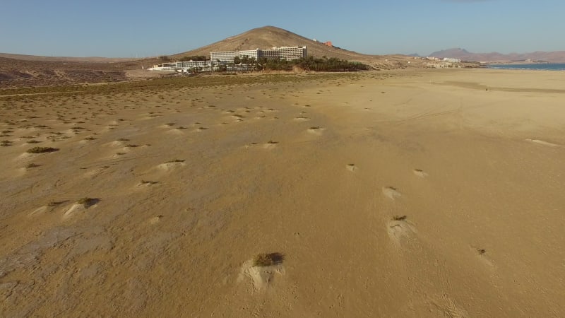 Aerial view of woman walking seaside at Sotavento lagoon beach.