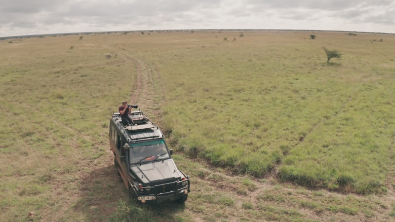 Orbit around photographer on safari vehicle taking pictures of African wildlife
