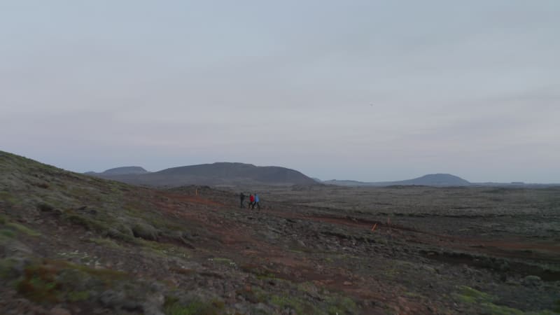 Surreal aerial view moonscape of Iceland desert countryside. Birds eye group of tourist explorer hikers walking pathway in icelandic highlands