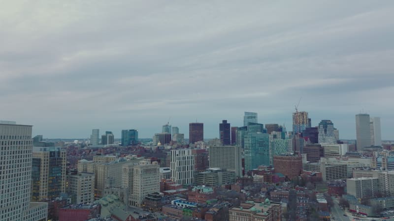 cityscape view downtown skyscrapers against grey cloudy sky. Forwards fly above city ad dusk. Boston, USA