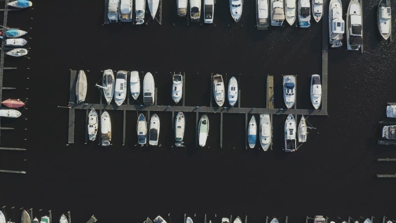 Top view of boats docked in the marina against dark water