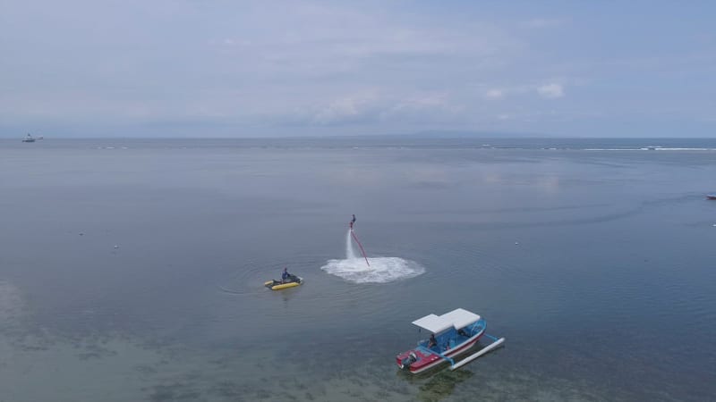 Aerial view of man practicing flyboard, Bali island.