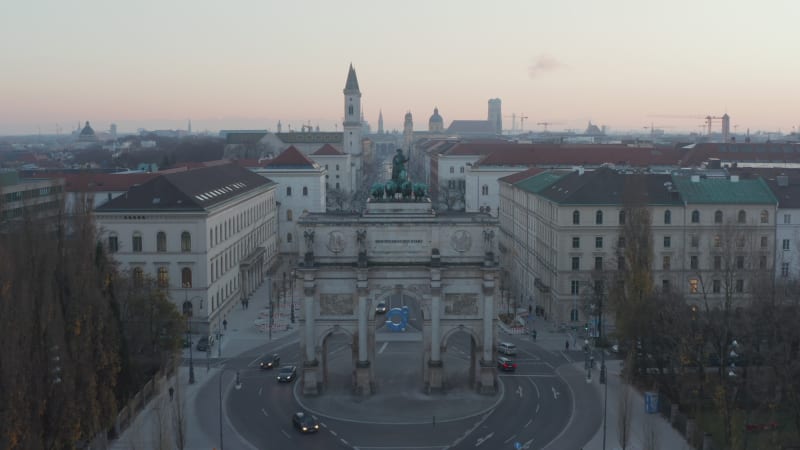 Siegestor in Munich, Germany in Beautiful Sunset Dusk scenic Cityscape with University in background, Aerial Dolly in towards