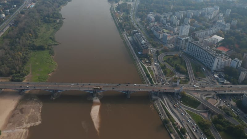 High angle view of heavy traffic on waterfront road and bridge spanning Vistula river. Vehicles driving in city. Warsaw, Poland