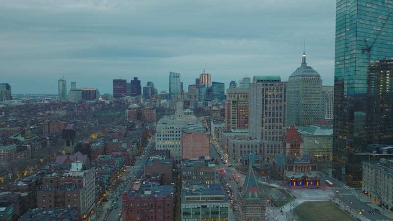 Fly above residential buildings in Back Bay Borough. Cityscape with modern high rise buildings in distance. Twilight in large city. Boston, USA