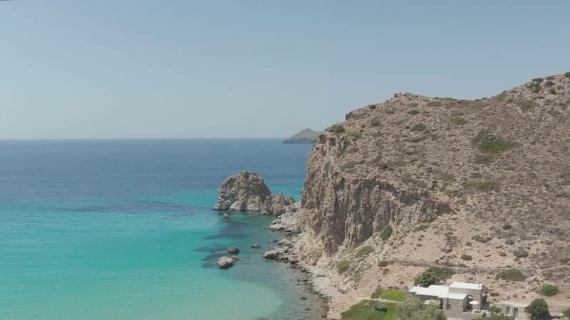 Slow Aerial Flight over Turquoise Blue Ocean with Rocky Cliff Coast