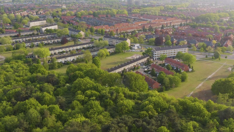 Aerial view of a city with houses surrounded by green trees in The Netherlands