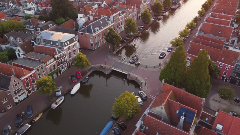 A boat moving on a canal in a residential area of Leiden, South Holland, Netherlands.