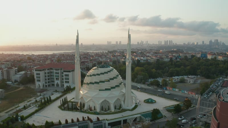 Futuristic Mosque in Beautiful Sunset in Istanbul, Modern looking Temple at Sunset with Cityscape, Aerial backwards