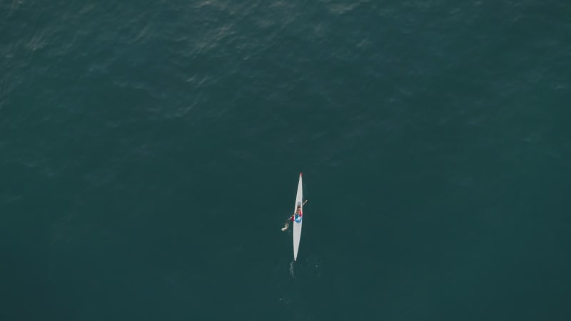 Aerial view above of a man paddling kayak in the sea.