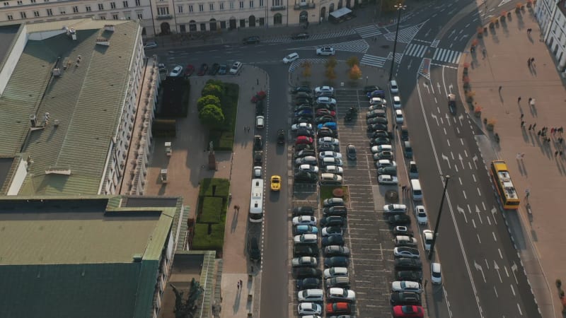 Forwards tracking of cars driving along parking lot in city. High angle view of traffic at Theatre Square. Warsaw, Poland