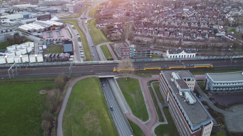 Aerial view of a train moving across an overpass in a densely populated part of Houten, Netherlands.