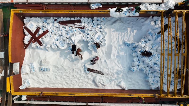 Aerial View of people unloading fertiliser from the boats in Bangladesh.