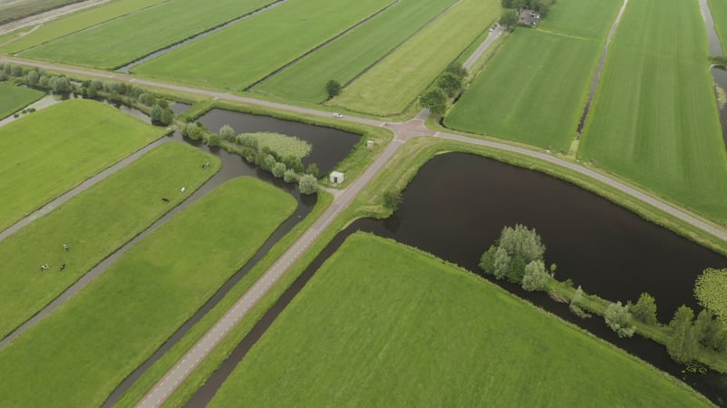 A cyclist and a car crossing a crossroads in rural countryside