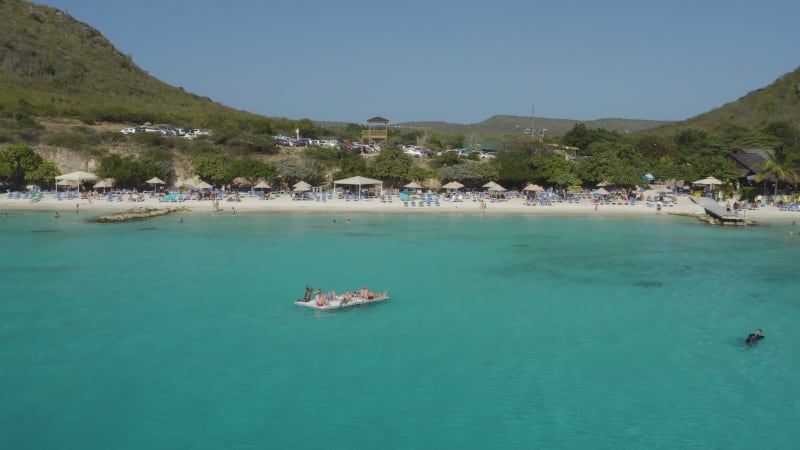 Friends Sunbathing on Raft at Playa Poro Marie, Curacao