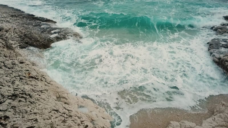 Aerial view of cliffs at Losinj coastline with agitated sea.