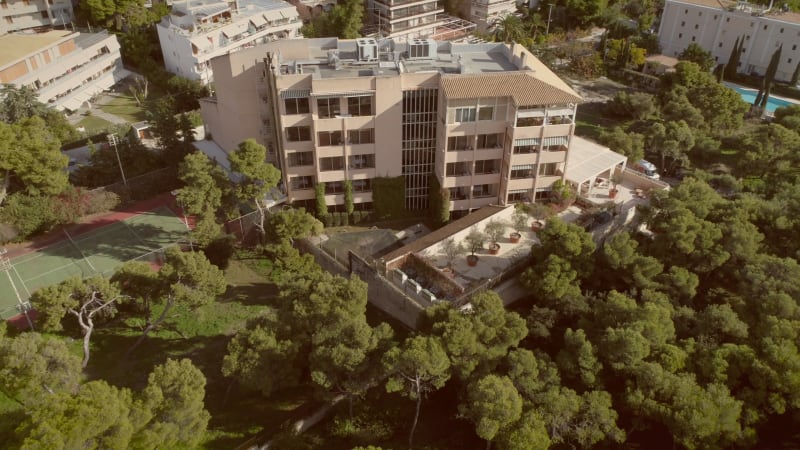 Aerial view of a residential building, surrounded by trees.