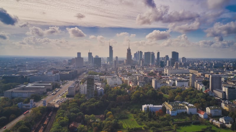 Morning forwards fly above city, hyperlapse of busy road and clouds flowing in sky. Skyline with tall modern office buildings. Warsaw, Poland