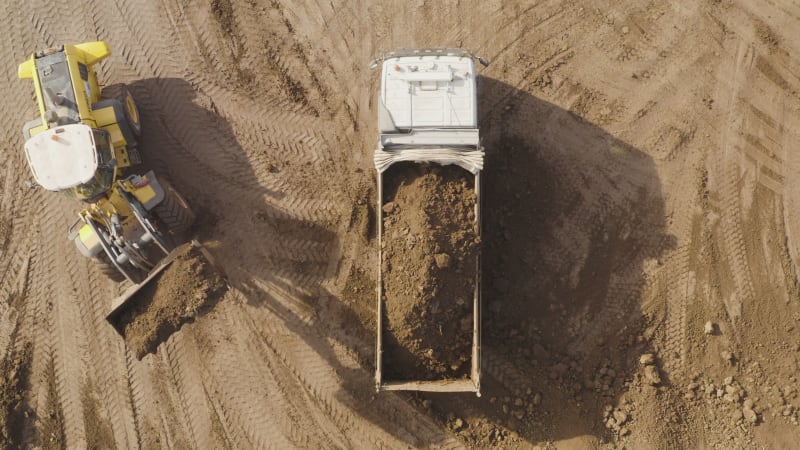 Bucket loader loading Trailer Truck with a load of Soil, Aerial view.