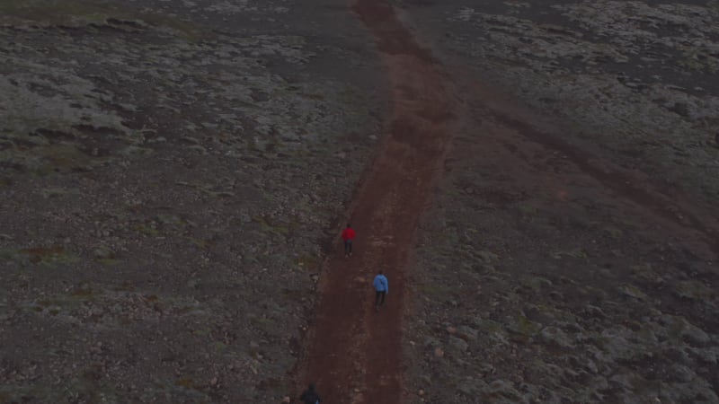 Aerial view tourist hiking walking pathway in isolated countryside in Iceland. Drone view adventurous traveler exploring icelandic highlands. Active lifestyle