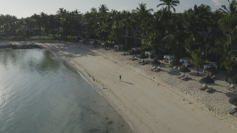 Aerial view of a blonde woman relaxing on the beach, Mauritius.