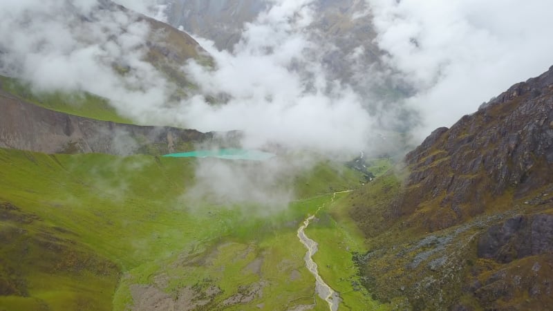 Aerial view of cloudy, snowy Humantay Lake.