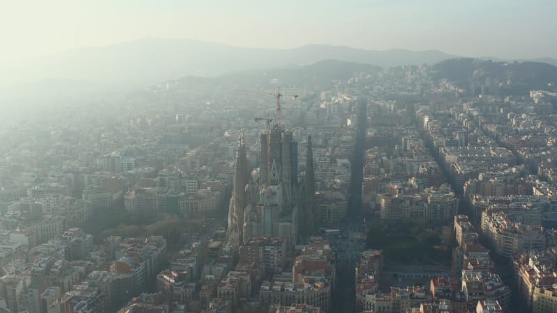 Towards La Sagrada Familia with Cranes in Beautiful City Sunny Haze over Barcelona, Spain