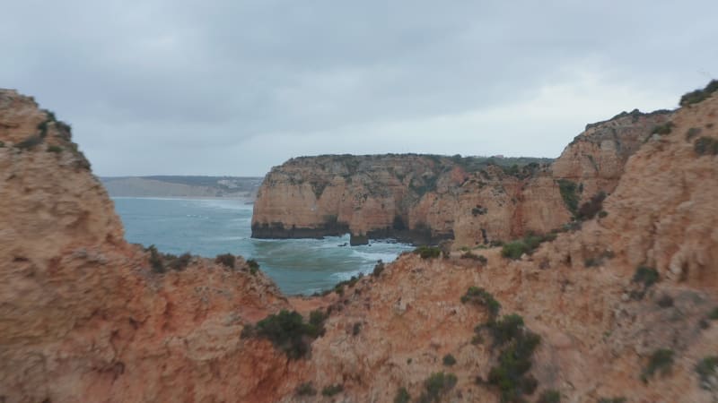 Aerial view of Lagos astonishing rocky cliff coastline, drone flying forward above coast reveal amazing background seascape view, cloudy day