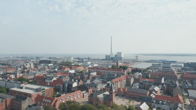 Forward slow flight over the city of Esbjerg with the Church of Our Saviour. Bird's eyes revealing his harbor with the chimney of the coal and oil fueled power plant, the tallest in Scandinavia