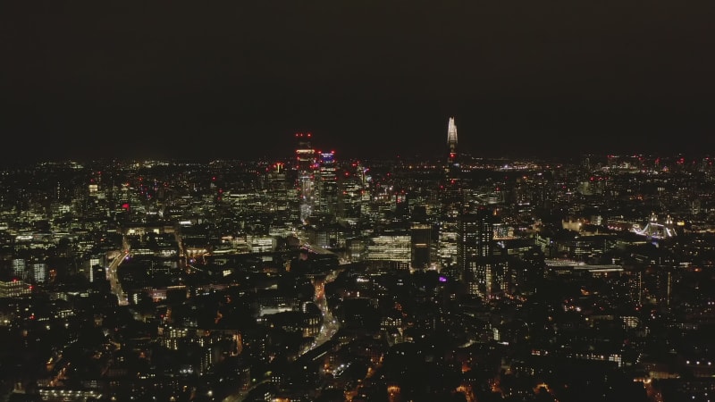 Aerial panoramic view of night cityscape. Illuminated tall modern skyscrapers and downtown buildings. London, UK